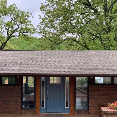 a tree in front of a brick building