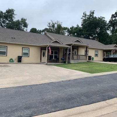 a house that has a sign on the side of a road